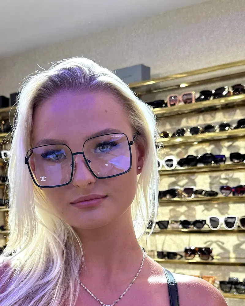 A visitor trying on tortoiseshell frames