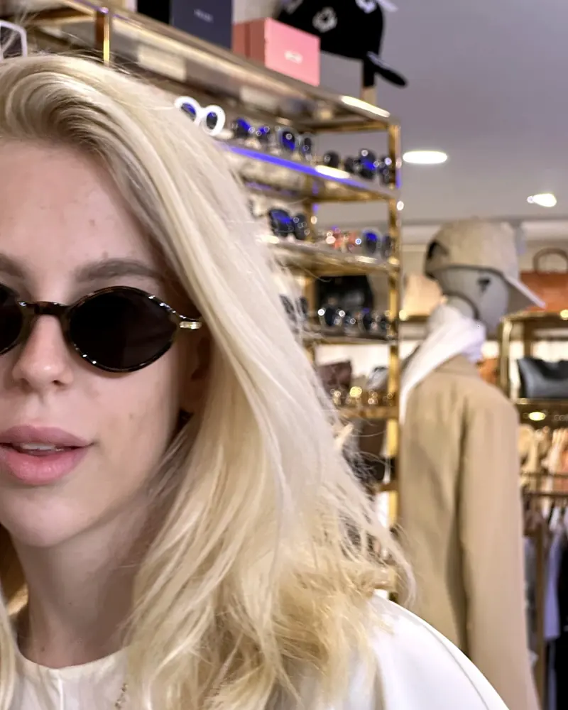 A visitor trying small oval sunglasses