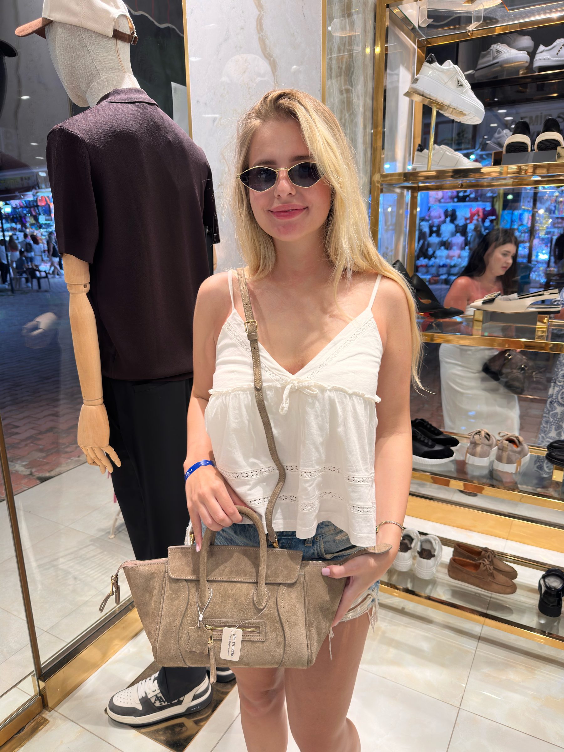 A suede BROTHERSBAG handbag carried in store